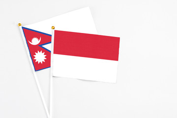 Indonesia and Nepal stick flags on white background. High quality fabric, miniature national flag. Peaceful global concept.White floor for copy space.