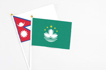 Macao and Nepal stick flags on white background. High quality fabric, miniature national flag. Peaceful global concept.White floor for copy space.