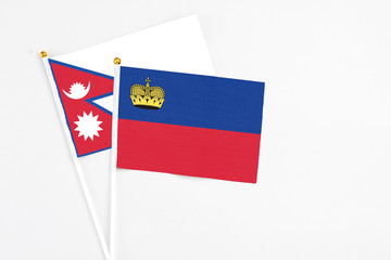 Liechtenstein and Nepal stick flags on white background. High quality fabric, miniature national flag. Peaceful global concept.White floor for copy space.