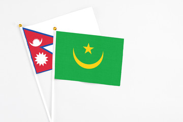 Mauritania and Nepal stick flags on white background. High quality fabric, miniature national flag. Peaceful global concept.White floor for copy space.