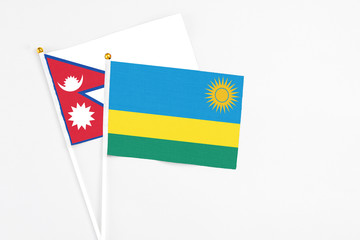 Rwanda and Nepal stick flags on white background. High quality fabric, miniature national flag. Peaceful global concept.White floor for copy space.
