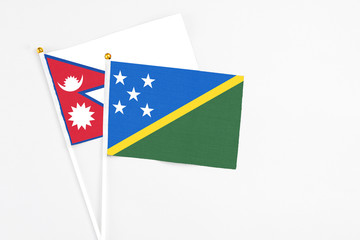 Solomon Islands and Nepal stick flags on white background. High quality fabric, miniature national...