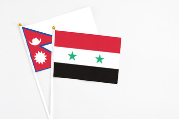 Syria and Nepal stick flags on white background. High quality fabric, miniature national flag. Peaceful global concept.White floor for copy space.
