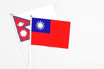 Taiwan and Nepal stick flags on white background. High quality fabric, miniature national flag. Peaceful global concept.White floor for copy space.