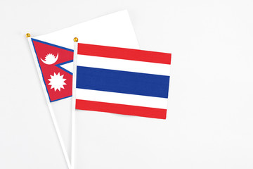 Thailand and Nepal stick flags on white background. High quality fabric, miniature national flag. Peaceful global concept.White floor for copy space.