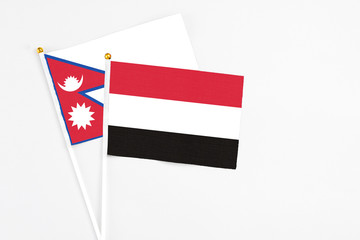 Yemen and Nepal stick flags on white background. High quality fabric, miniature national flag. Peaceful global concept.White floor for copy space.