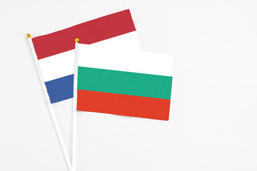 Bulgaria and Netherlands stick flags on white background. High quality fabric, miniature national flag. Peaceful global concept.White floor for copy space.