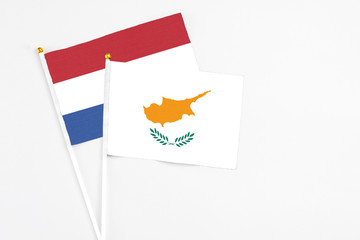 Cyprus and Netherlands stick flags on white background. High quality fabric, miniature national flag. Peaceful global concept.White floor for copy space.