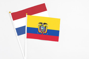 Ecuador and Netherlands stick flags on white background. High quality fabric, miniature national flag. Peaceful global concept.White floor for copy space.