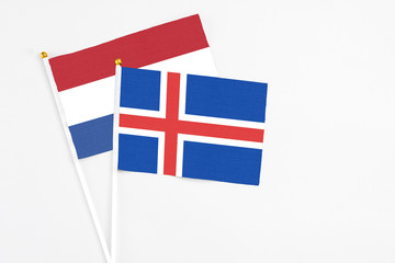 Obraz premium Iceland and Netherlands stick flags on white background. High quality fabric, miniature national flag. Peaceful global concept.White floor for copy space.