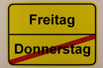 Grafische Darstellung der Wochentage Freitag und Donnerstag auf einem Ortsschild