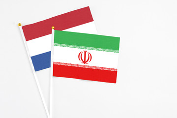 Iran and Netherlands stick flags on white background. High quality fabric, miniature national flag. Peaceful global concept.White floor for copy space.