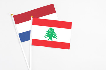 Lebanon and Netherlands stick flags on white background. High quality fabric, miniature national flag. Peaceful global concept.White floor for copy space.