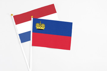 Liechtenstein and Netherlands stick flags on white background. High quality fabric, miniature national flag. Peaceful global concept.White floor for copy space.