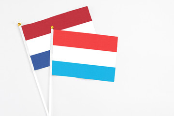 Luxembourg and Netherlands stick flags on white background. High quality fabric, miniature national flag. Peaceful global concept.White floor for copy space.