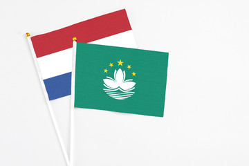 Macao and Netherlands stick flags on white background. High quality fabric, miniature national flag. Peaceful global concept.White floor for copy space.