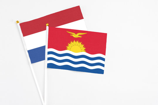 Kiribati and Netherlands stick flags on white background. High quality fabric, miniature national flag. Peaceful global concept.White floor for copy space.