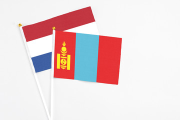 Mongolia and Netherlands stick flags on white background. High quality fabric, miniature national flag. Peaceful global concept.White floor for copy space.