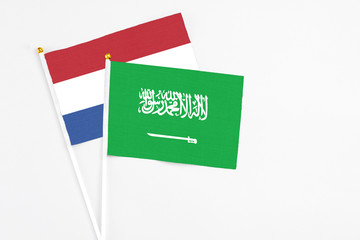 Saudi Arabia and Netherlands stick flags on white background. High quality fabric, miniature national flag. Peaceful global concept.White floor for copy space.