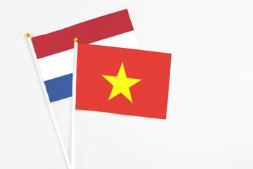Vietnam and Netherlands stick flags on white background. High quality fabric, miniature national flag. Peaceful global concept.White floor for copy space.