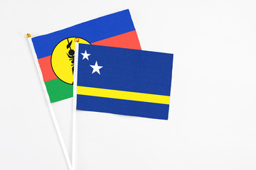 Curacao and New Caledonia stick flags on white background. High quality fabric, miniature national flag. Peaceful global concept.White floor for copy space.