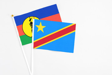Congo and New Caledonia stick flags on white background. High quality fabric, miniature national flag. Peaceful global concept.White floor for copy space.