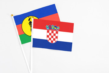 Croatia and New Caledonia stick flags on white background. High quality fabric, miniature national...
