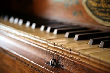 Close up shallow focus shot of a vintage piano or harpsichord keyboard, made of ebony, ivory and hardwood