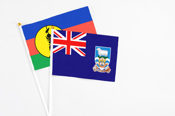 Falkland Islands and New Caledonia stick flags on white background. High quality fabric, miniature national flag. Peaceful global concept.White floor for copy space.