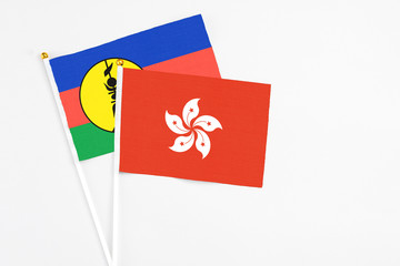 Hong Kong and New Caledonia stick flags on white background. High quality fabric, miniature national flag. Peaceful global concept.White floor for copy space.