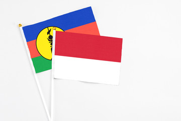 Indonesia and New Caledonia stick flags on white background. High quality fabric, miniature national flag. Peaceful global concept.White floor for copy space.