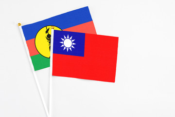 Taiwan and New Caledonia stick flags on white background. High quality fabric, miniature national flag. Peaceful global concept.White floor for copy space.