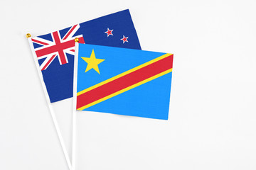 Fototapeta premium Congo and New Zealand stick flags on white background. High quality fabric, miniature national flag. Peaceful global concept.White floor for copy space.
