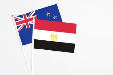 Egypt and New Zealand stick flags on white background. High quality fabric, miniature national flag. Peaceful global concept.White floor for copy space.
