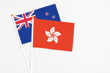 Hong Kong and New Zealand stick flags on white background. High quality fabric, miniature national flag. Peaceful global concept.White floor for copy space.