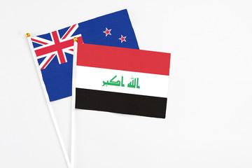 Fototapeta premium Iraq and New Zealand stick flags on white background. High quality fabric, miniature national flag. Peaceful global concept.White floor for copy space.