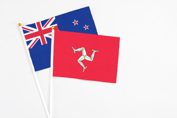 Isle Of Man and New Zealand stick flags on white background. High quality fabric, miniature national flag. Peaceful global concept.White floor for copy space.