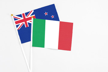 Italy and New Zealand stick flags on white background. High quality fabric, miniature national flag. Peaceful global concept.White floor for copy space.