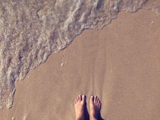 Woman legs on sand beach.