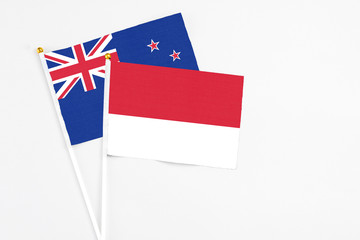 Monaco and New Zealand stick flags on white background. High quality fabric, miniature national flag. Peaceful global concept.White floor for copy space.