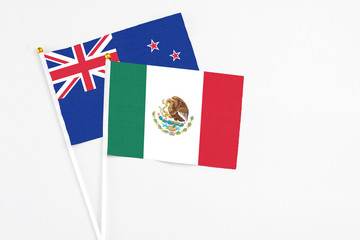 Mexico and New Zealand stick flags on white background. High quality fabric, miniature national flag. Peaceful global concept.White floor for copy space.