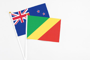 Republic Of The Congo and New Zealand stick flags on white background. High quality fabric, miniature national flag. Peaceful global concept.White floor for copy space.