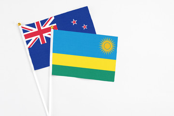 Rwanda and New Zealand stick flags on white background. High quality fabric, miniature national flag. Peaceful global concept.White floor for copy space.