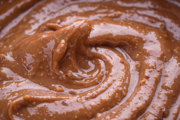 peanut butter and peanuts on grey background , top view