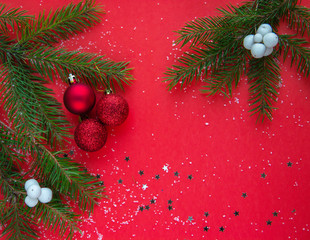 Christmas flatlay with green christmas tree branches and red ball 