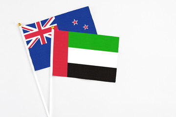 United Arab Emirates and New Zealand stick flags on white background. High quality fabric, miniature national flag. Peaceful global concept.White floor for copy space.