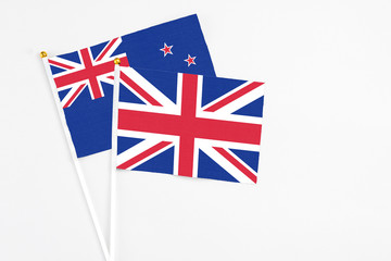 United Kingdom and New Zealand stick flags on white background. High quality fabric, miniature national flag. Peaceful global concept.White floor for copy space.