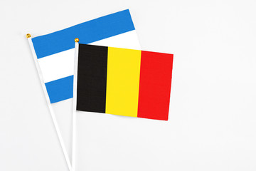 Belgium and Nicaragua stick flags on white background. High quality fabric, miniature national flag. Peaceful global concept.White floor for copy space.