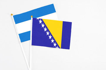Bosnia Herzegovina and Nicaragua stick flags on white background. High quality fabric, miniature...