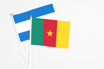 Cameroon and Nicaragua stick flags on white background. High quality fabric, miniature national flag. Peaceful global concept.White floor for copy space.